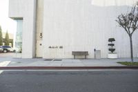 a bench is sitting near the curb in front of the building with no people on it