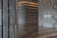 a large marble room with the floor polished and tiled in grey marble with silver metal columns