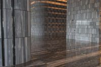 a large marble room with the floor polished and tiled in grey marble with silver metal columns