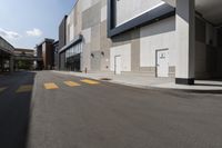 there is a yellow crosswalk at this city area on an empty street near a building