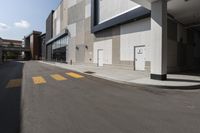 there is a yellow crosswalk at this city area on an empty street near a building