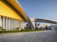 the building has multiple curved sections on each side of it, with grass between them