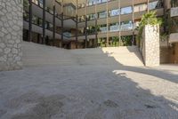 this is an outdoor courtyard in this modern building with a stone stairway and steps leading down to the courtyard