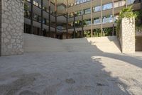 this is an outdoor courtyard in this modern building with a stone stairway and steps leading down to the courtyard