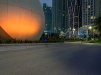 a woman walks past an orange sphere building, with palm trees nearby, in a city