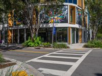 the street has a zebra crossing in front of it and many plants on the sidewalk