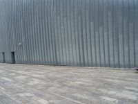 the little girl is riding a skateboard on the pavement near the wall of the building