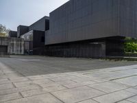 the large building has several black walls in it and a dog laying on the ground outside