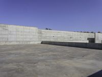 the concrete floor and wall have two empty ramps on one side and no one has a sky background