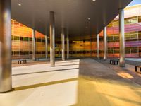 sunlight shines through pillars, along with colorful glass in the building's center