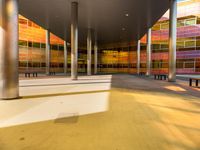 sunlight shines through pillars, along with colorful glass in the building's center