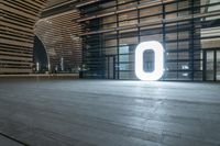 an empty open space with light coming through it and people looking around it at a large window and two large letters that read'00