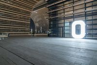 an empty open space with light coming through it and people looking around it at a large window and two large letters that read'00