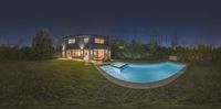 the swimming pool sits in a backyard area next to a building at night with lights shining