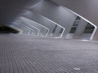 a very modern, shiny and empty building at night, with light shining through windows