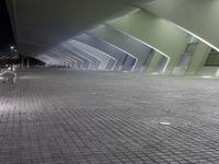 a very modern, shiny and empty building at night, with light shining through windows