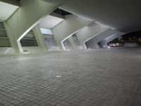 a very modern, shiny and empty building at night, with light shining through windows