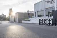 the front end of a business building with a paved street and trees in the background