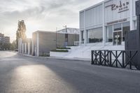 the front end of a business building with a paved street and trees in the background