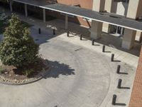 a school courtyard features concrete, trees and benches for students to use in the day