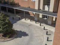 a school courtyard features concrete, trees and benches for students to use in the day