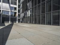 the entrance to an office building, with lots of windows open and shadows coming from the building