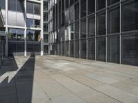 the entrance to an office building, with lots of windows open and shadows coming from the building