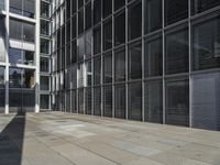 the entrance to an office building, with lots of windows open and shadows coming from the building