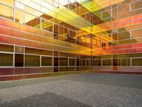 a large building with multi colored windows and a black floor inside of it in front of the sky