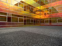 a large building with multi colored windows and a black floor inside of it in front of the sky