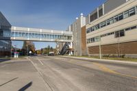 a street with a bridge and cars going under it in front of buildings on both sides