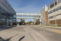 a street with a bridge and cars going under it in front of buildings on both sides