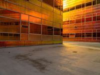 orange and yellow building with some windows with a clock in the center with no one