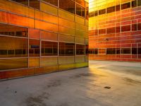 orange and yellow building with some windows with a clock in the center with no one