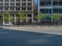 an empty street with buildings and parked cars on the sidewalks and green lanes on the sidewalk