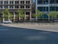 an empty street with buildings and parked cars on the sidewalks and green lanes on the sidewalk