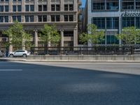 an empty street with buildings and parked cars on the sidewalks and green lanes on the sidewalk