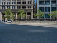 an empty street with buildings and parked cars on the sidewalks and green lanes on the sidewalk