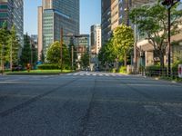 an empty road with a street sign at the curb in front of an office building