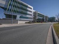 the road in front of a large building with several windows and one side lane with an empty street