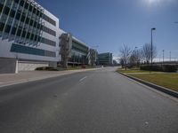 the road in front of a large building with several windows and one side lane with an empty street