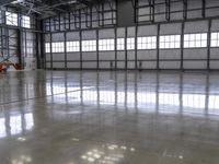 a warehouse with a shiny polished floor and concrete floors and red pipe spigong equipment