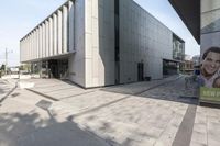 the building has a large advertisement near by it's entrance entrance entrance walkway with stairs