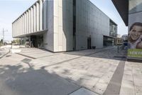 the building has a large advertisement near by it's entrance entrance entrance walkway with stairs