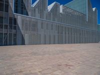 a white building with several steps and large glass panels in the facade is a mosaic that depicts a man