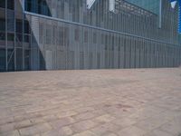 a white building with several steps and large glass panels in the facade is a mosaic that depicts a man