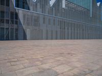 a white building with several steps and large glass panels in the facade is a mosaic that depicts a man