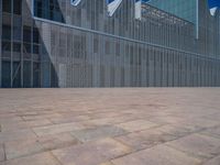 a white building with several steps and large glass panels in the facade is a mosaic that depicts a man