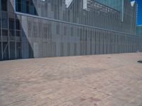 a white building with several steps and large glass panels in the facade is a mosaic that depicts a man