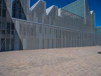 a white building with several steps and large glass panels in the facade is a mosaic that depicts a man